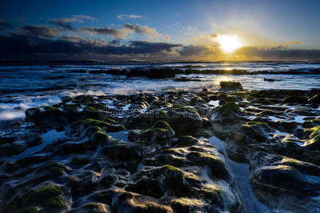 思想的曙光初现;波涛在岩石海岸上冲刷照片
