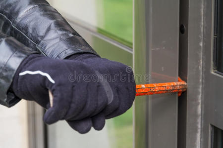 窃贼穿着皮大衣在房子里破门而入照片