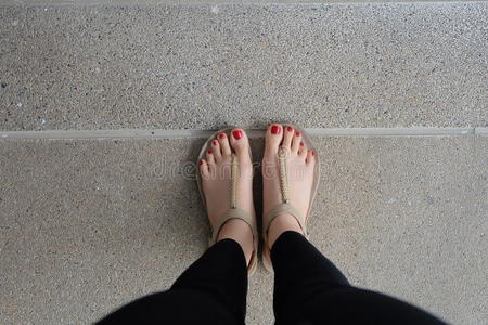 女性脚穿拖鞋或触发器户外红色指甲