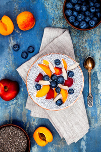 排毒和健康超级食品早餐碗的概念。 纯素椰奶奇亚种子布丁在乡村餐桌上与各种水果