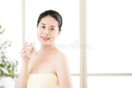 美丽的亚洲妇女淋浴后用微笑的脸喝水
