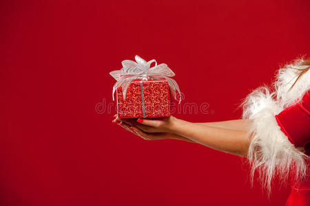 圣诞节。红色背景，手拿礼品盒