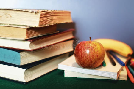 教育书籍堆叠，苹果和钢笔