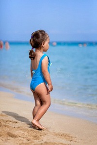 可爱的小女孩站在热带海滩上
