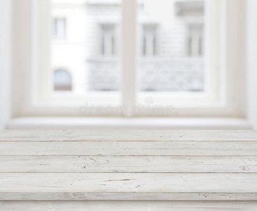 在模糊的窗户上展示产品的空木桌面