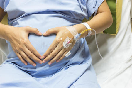 亚洲孕妇在医院贵宾室接受盐水点滴治疗.照片