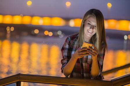 好消息. 年轻快乐的女人微笑着在手机上发短信照片
