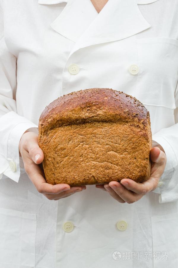 面包师手里拿着新鲜面包