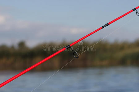 在湖边用鱼竿钓鱼