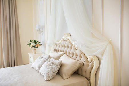 卧室采用柔和的浅色。 大舒适的双人床在优雅的经典内部