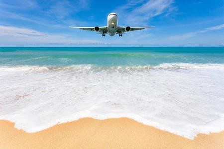 飞机降落在美丽的海滩和海洋背景之上。