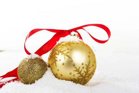白色雪中的金色圣诞装饰品作为背景