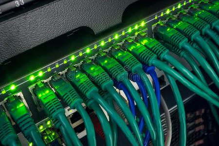 连接到交换机发光的绿色网络电缆特写手持网线光纤 st 和 mtp (mpo)