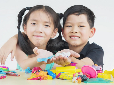 亚洲孩子玩彩色粘土玩具