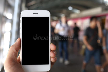 手持智能手机与地铁站背景