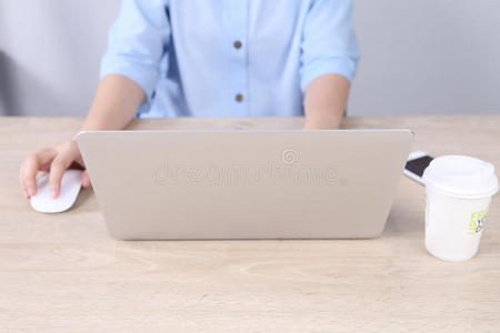 商务女性使用笔记本电脑和智能手机在木桌上