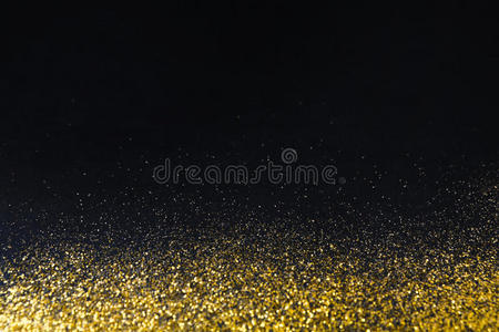 金色闪光的沙子纹理边界在黑色，抽象的背景。