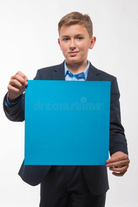 情感少年男孩金发，穿着蓝色西装，带着一张蓝色的纸作笔记