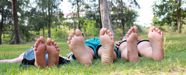 一群快乐的孩子躺在绿色的草地上。
