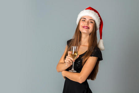 戴着香槟的圣诞老人帽子的漂亮女人