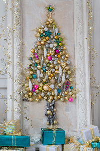 美丽的室内客厅装饰圣诞节。 大镜子框架与一棵由球和玩具组成的树