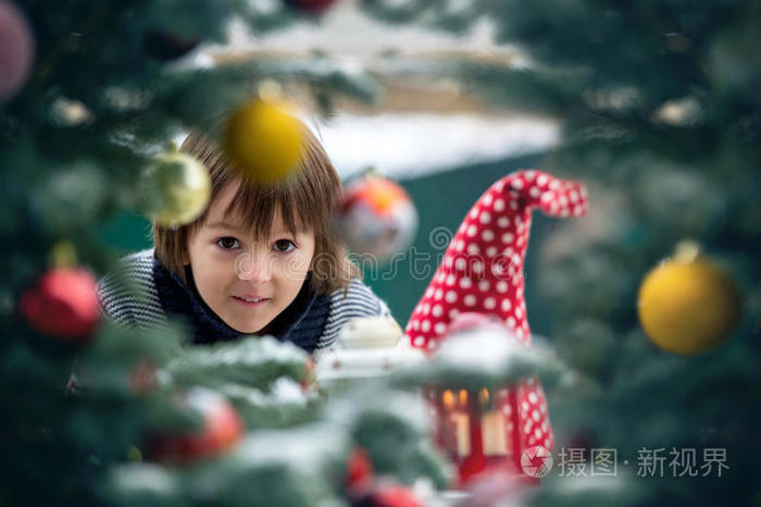 可爱的孩子，男孩，站在圣诞树后面，快乐的脸