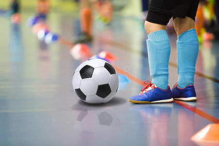 儿童训练足球普特斯室内健身房。 带足球的小男孩训练室内足球。 浅蓝色运动的小球员