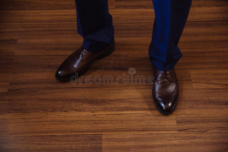 商人穿着经典优雅的鞋子。 新郎在婚礼当天穿着，系鞋带和准备。