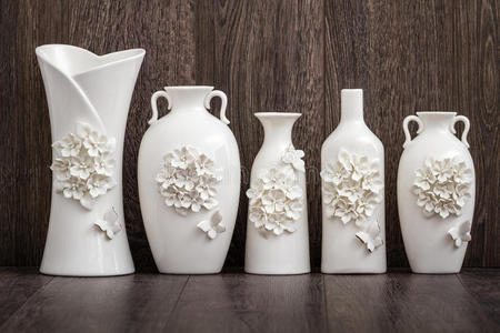 棕色背景上不同的装饰白色花瓶