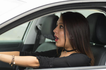 特写年轻女性坐在汽车上，与互动惊讶，从外面的司机窗口看到，女性