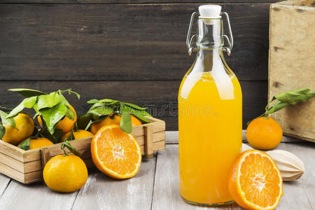 一瓶橘子汁和木制背景上的新鲜水果