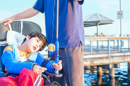 轮椅上的残疾男孩和父亲一起钓鱼