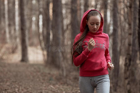 运动的年轻女人在大自然中奔跑。