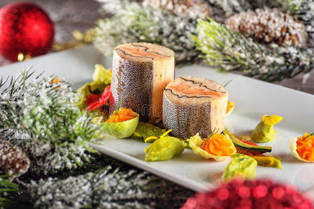 带圣诞装饰的白色盘子上的鱼发酵食品。 产品摄影和现代美食