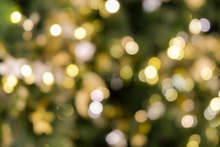 圣诞树亮着绿色黄色金色，节日抽象背景，模糊散焦