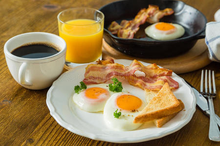美式早餐，包括阳光明媚的鸡蛋培根吐司煎饼咖啡和果汁