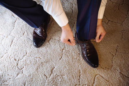 商人穿着经典优雅的鞋子。 新郎在婚礼当天穿着，系鞋带和准备。