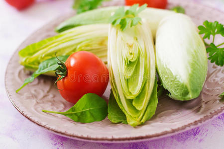 新鲜健康的菊苣沙拉和番茄放在盘子里。
