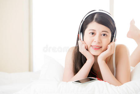 亚洲女人用带耳机的智能手机享受音乐