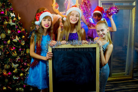 一群年轻女孩庆祝圣诞节。 黑板