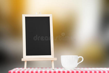 黑板菜单，咖啡杯显示在织物桌面上