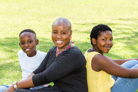 有两个孩子的非洲母亲的家庭肖像.照片