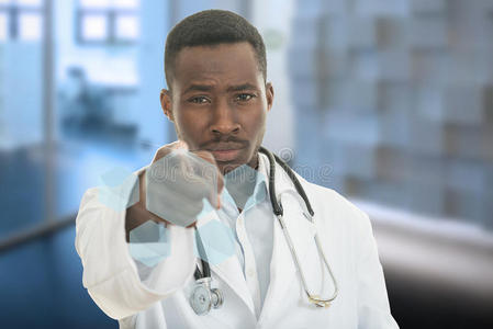 愤怒的非洲黑人男医生用听诊器指着你