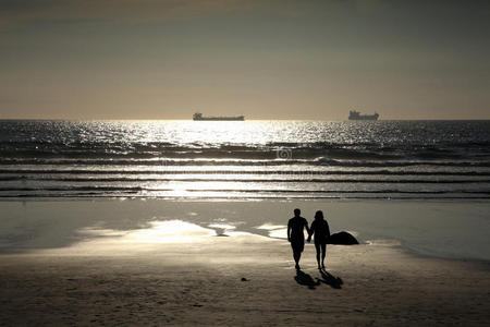 一对夫妇在夕阳海滩上散步