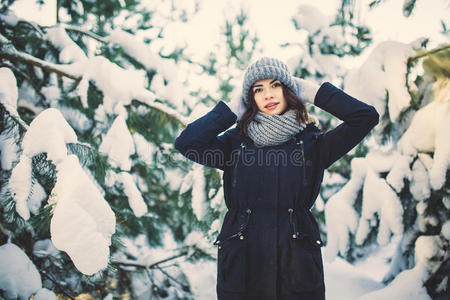 美丽的年轻女人在公园里下雪的冬天。