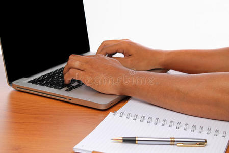 手在老式木桌上打字笔记本电脑