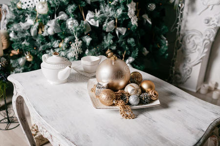 桌子上的圣诞装饰品是在壁炉的背景下装饰的，上面花环装饰的壁炉。