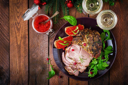 圣诞烤火腿和红色鱼子酱，放在旧木桌上。