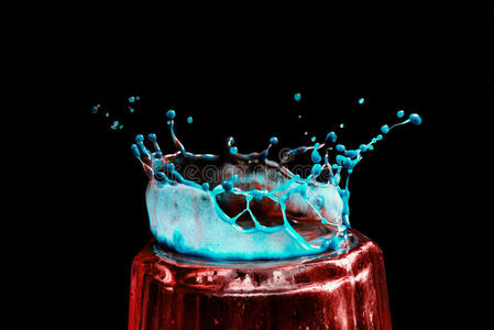 五颜六色的特写，蓝色和红色的皇冠形式的水滴在玻璃上裂开