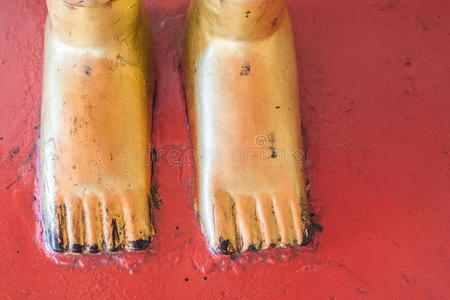 金金属佛像红色地板上佛像的金脚照片